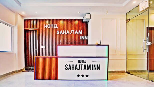 En receptionsdisk med skiltet "HOTEL SAHAJTAM INN" og en trævæg med lodrette lister bagved.