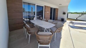 A patio with a table and chairs, large windows, and a view of the landscape. - New villa Angelo 2025 ( family and pet friendly) (Privlaka)