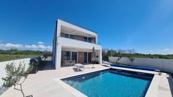 A modern two-story house with a swimming pool.