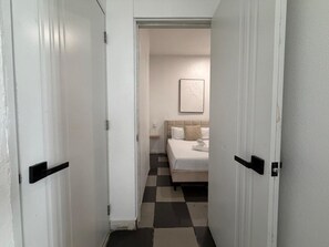 A hotel room with a bed, a bedside table, and a wall-mounted artwork.