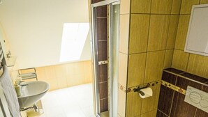 A bathroom with a shower, toilet, and sink.