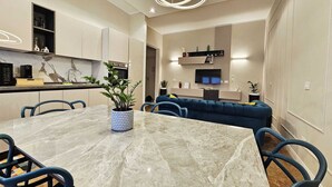 A modern kitchen with white cabinets, a marble countertop, and a built-in oven.