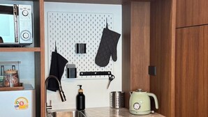 A compact kitchenette with a microwave, kettle, and kettle holder. - Charming 3-bedroom house with AC, WiFi in marvelous Bangkok (Krung Thep Maha Nakhon)
