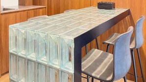 A modern meeting room with a glass-topped table, wooden panel walls, and two chairs. - Charming 3-bedroom house with AC, WiFi in marvelous Bangkok (Krung Thep Maha Nakhon)