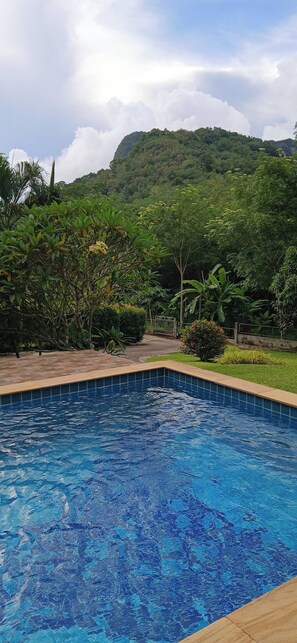 A swimming pool with a tiled edge, surrounded by lush greenery and a mountainous backdrop. - WoW ! So Peaceful ! Super Cool, Jungle View, 3 Bed Pool Villa > Krabi - Thailand (Nong Thale)