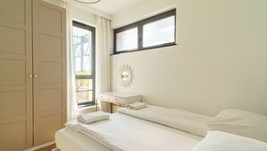 Un dormitorio con cama, escritorio y armario.