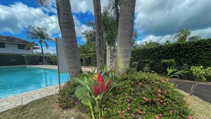A swimming pool surrounded by palm trees and lush greenery. - Apartment Tahiti near hospital, wifi,A&C,Swimming pool (Pirae)