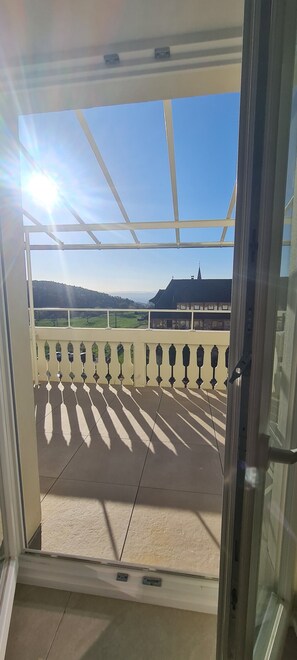 Enjoy a serene outdoor space with a balcony featuring a glass door and metal railing.