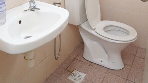 Ein Badezimmer mit Waschbecken, Toilette und Handtrockner.