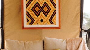 Un'accogliente zona living con un divano, cuscini, un vaso e un'opera d'arte incorniciata al muro.