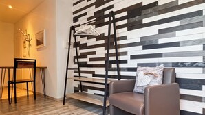 A modern living room with a sectional sofa, a black metal ladder, and a wall with a geometric wood panel design. - La Maison Bleue, on the Bay of the Somme, in a peaceful natural setting (Pendé)