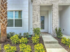 Welcoming Front Entrance with Stone Pillars and Landscaping