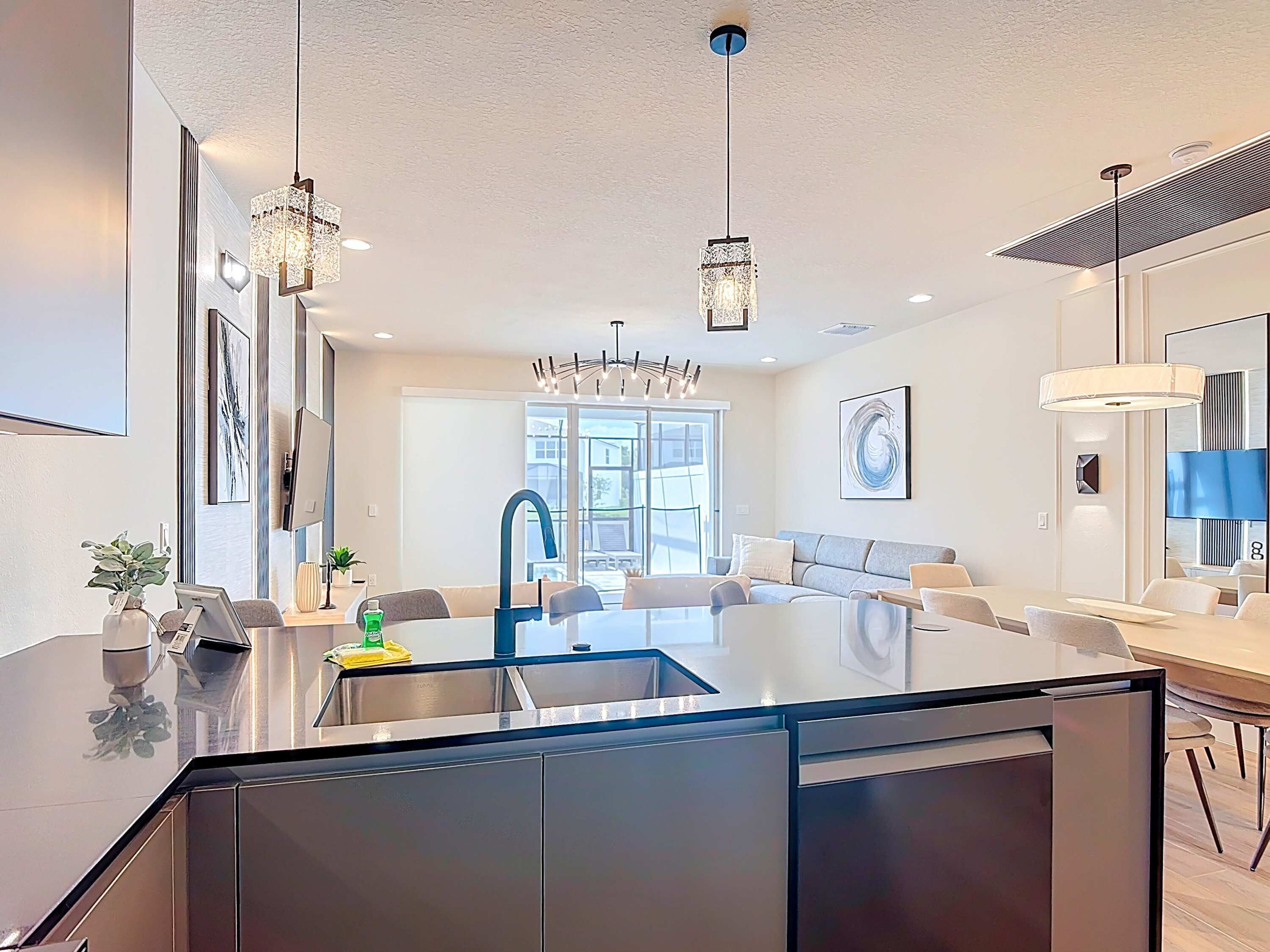 A modern kitchen with a central island, stainless steel appliances, and pendant lighting.