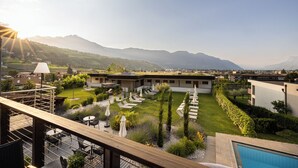 Ein moderner Außenbereich mit Pool, Liegestühlen und einem gepflegten Rasen.