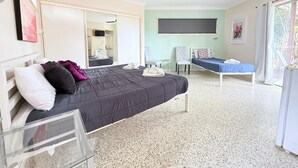 Une chambre à coucher avec un lit, une chaise, un bureau et un ventilateur de plafond.