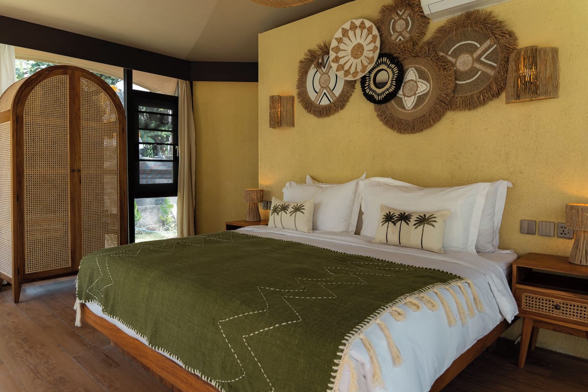 Ein Schlafzimmer mit Bett, Fenster, Tür und Wanddekorationen.
