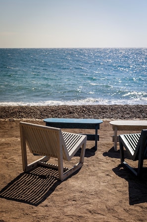 On the beach, black sand, sun loungers, beach umbrellas