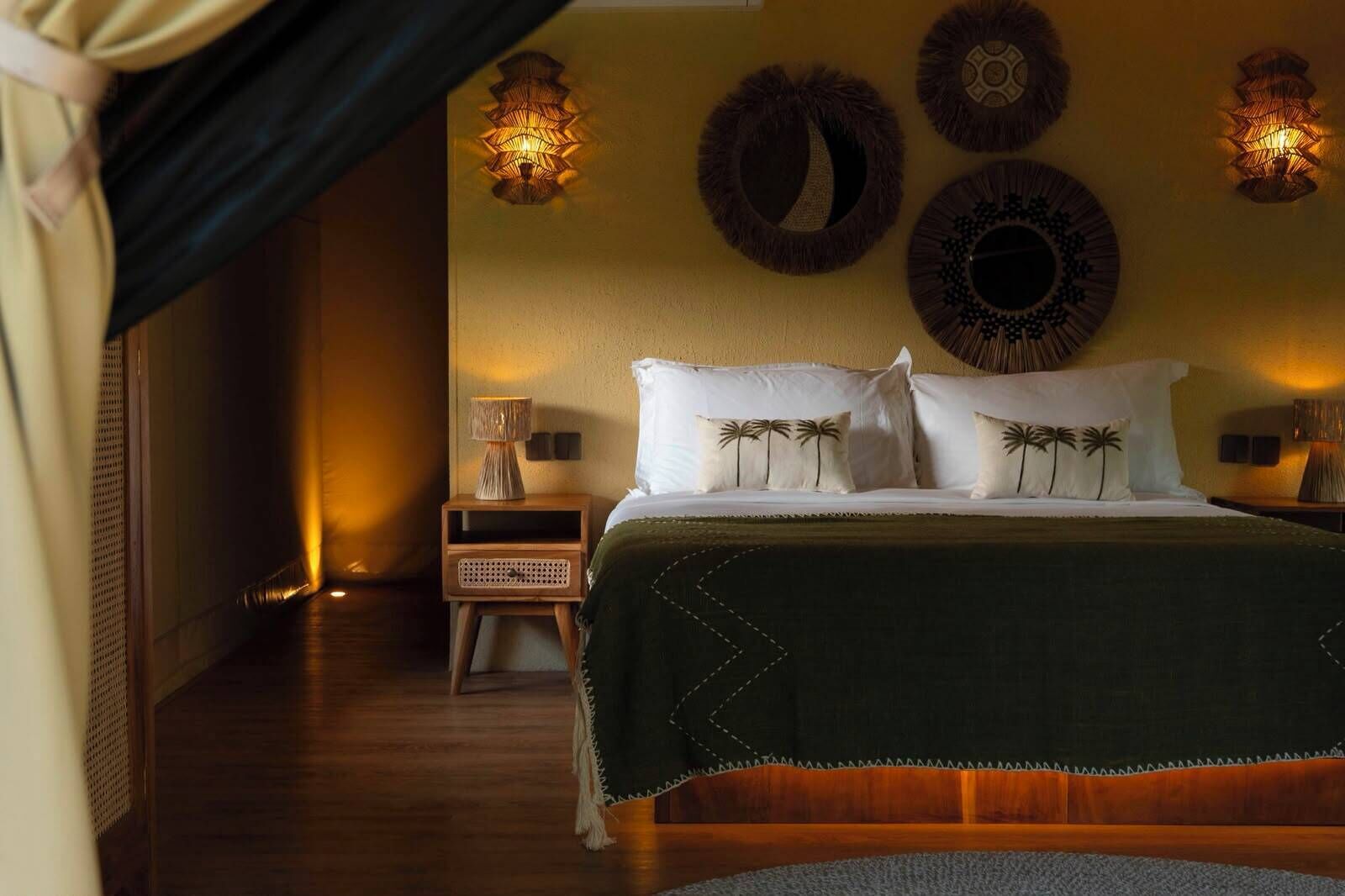 A hotel room with a bed, nightstands, wall decor, and a curtain.