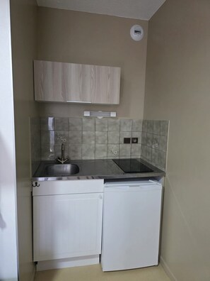 A compact kitchen with a sink, a dishwasher, and a stove.
