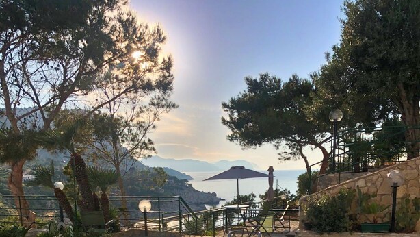 Una piscina con vistas despejadas al mar y montañas al fondo.
