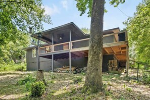 A modern two-story house with a large garage, surrounded by trees.