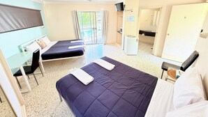 Une chambre d’hôtel avec deux lits, un bureau, une télévision et un balcon.