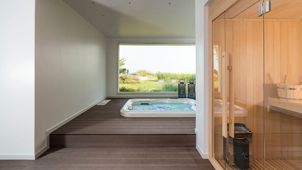 A modern bathroom with a wooden floor, a glass shower enclosure, and a view of a green landscape. - Villa Bel Prato with pool - My Rental Homes (Modica)