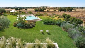 A private pool with a view of the countryside, surrounded by well-maintained lawns and garden beds. - Villa Bel Prato with pool - My Rental Homes (Modica)