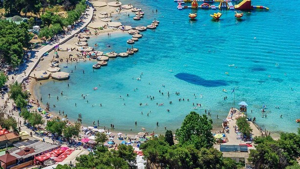 An aerial view of a beach with clear waters, boats, and a water park. - Studio in Vodice Near Male Vrulje Beach (Vodice)
