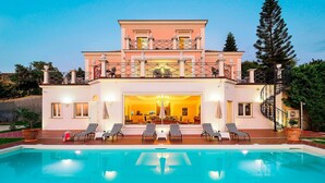 Una casa de dues plantes amb una piscina al davant.