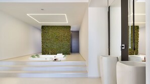 A modern bathroom with a green moss wall, a large mirror, and a white sink. - Villa Inga with private pool - My Rental Homes (Calatabiano)