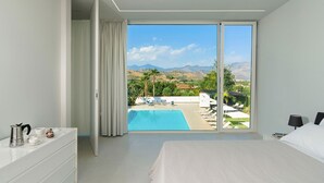 A bedroom with a large sliding glass door leading to a pool area with lounge chairs and a view of mountains. - Villa Inga with private pool - My Rental Homes (Calatabiano)