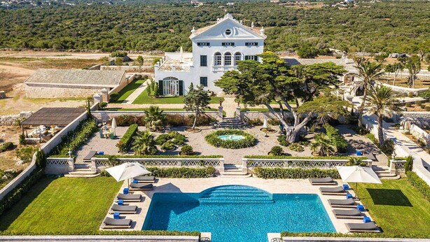 A large white building with a central tower, surrounded by a well-maintained garden and a swimming pool with sun loungers. - My Rental Homes - Finca Design 10-min drive from Mahon with swimming pool (Mahon)