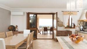 Eine moderne Küche mit Essbereich, Meerblick und einem Balkon.