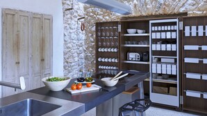 Une cuisine moderne avec un mur en pierre, un bar intégré et divers éléments de rangement.