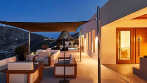 Ein moderner Außenbereich zum Sitzen mit Pool, großem Sonnenschirm und Blick auf die Berge.