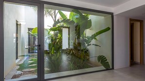 A modern interior with a large sliding glass door leading to a lush garden area.