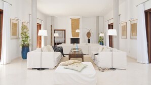 Una sala de estar moderna con sofás blancos, una mesa de centro y una chimenea.