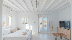 Une chambre à coucher avec un lit, une télévision, une armoire en bois et une vue sur l’extérieur.