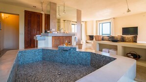 A modern bathroom with a large bathtub, a vanity with a mirror, and a shower area.