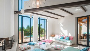 A spacious living area with large windows, a modern sofa set, and a coffee table.