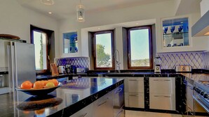 Una cocina moderna con una isla grande, electrodomésticos integrados y amplios ventanales con vistas.