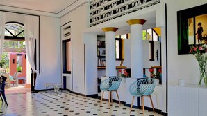 Un interior moderno con suelo estampado, una zona de estar con sillas y una estantería.