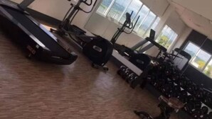 Een sportschool met cardioapparatuur, krachtapparaten en losse gewichten.