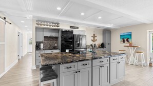 A modern kitchen with grey cabinets, a granite countertop, and stainless steel appliances. - GameRoom | Canal | Large Dock | Pool | Pets OK! 6 beds (Palm Coast)