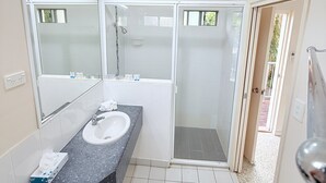 Une salle de bain moderne avec un grand lavabo, une cabine de douche et des toilettes.