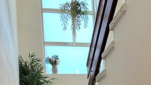 A staircase with a terrazzo finish, leading to a landing with a window and a potted plant. - AS NEVEIRAS, TYPICAL GALICIAN RURAL HOUSE (Fixó)