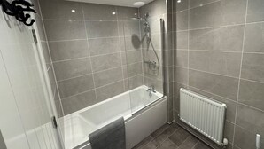 A modern bathroom with a glass-enclosed shower, a standalone bathtub, and a white radiator. - Upper Townhouse, Exeter (Devon)