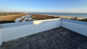 Ein Balkon mit Blick auf Strand und Küstenlandschaft.