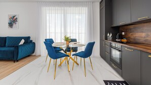 Une cuisine moderne avec des meubles de couleur sombre, des poignées dorées et un plan de travail en bois.